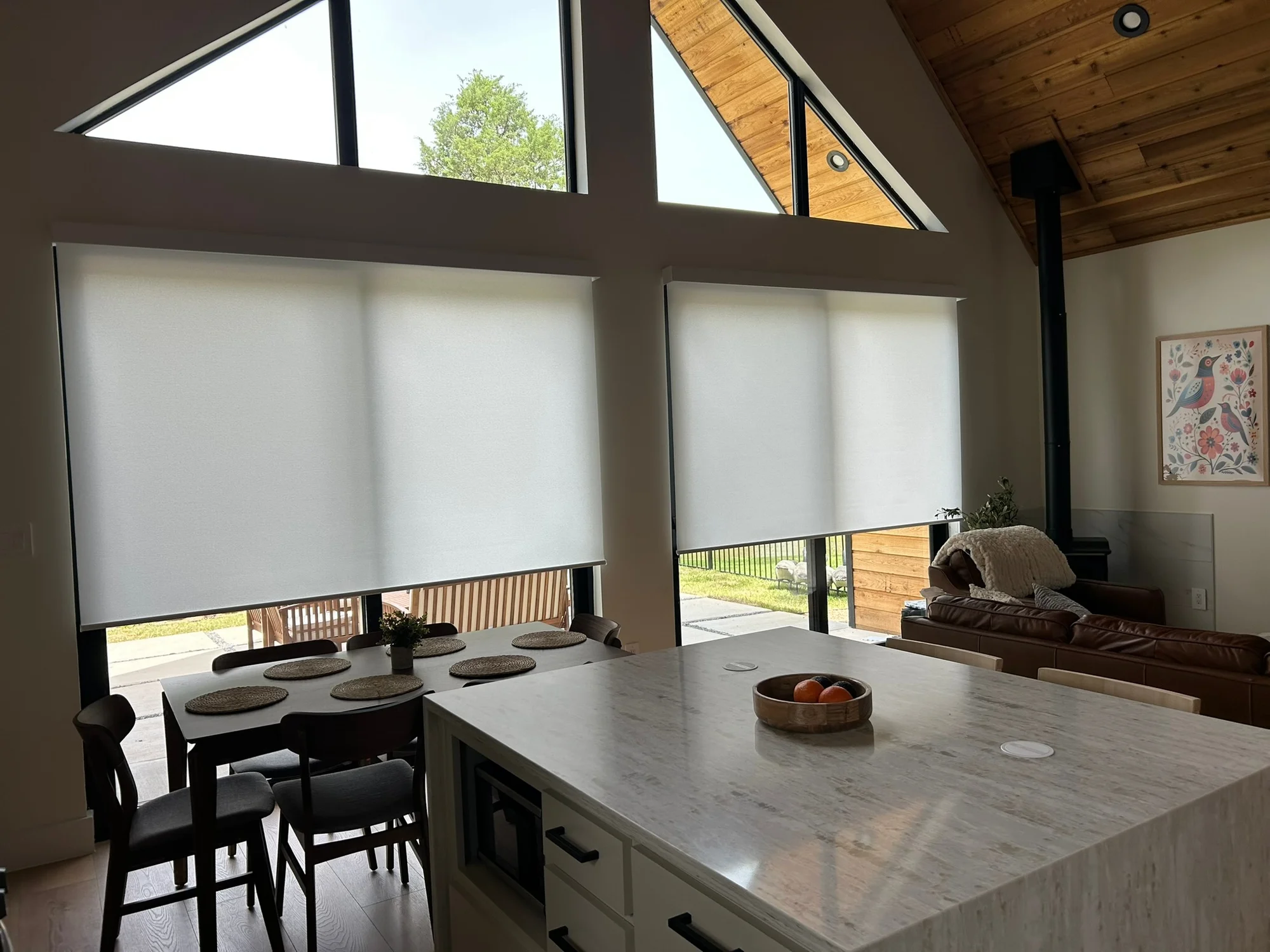 Roller shades on tall windows in an open Texas kitchen