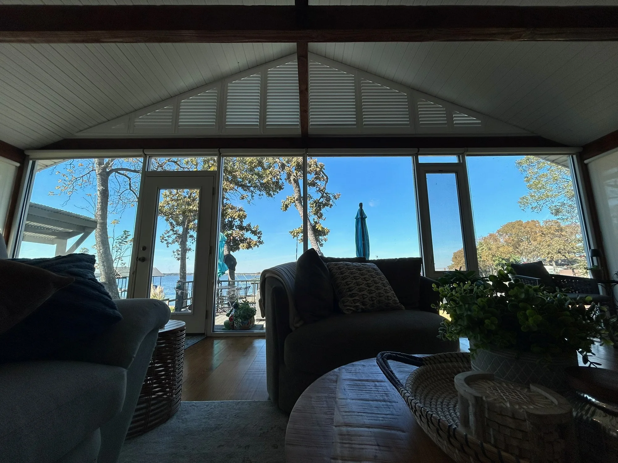 Plantation shutters framing a lake view in a Texas living room